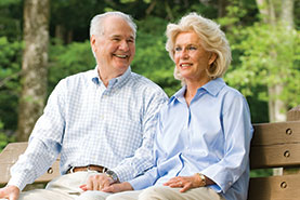 Photo of a couple sitting on a park bench. Link to Gifts of Appreciated Securities.